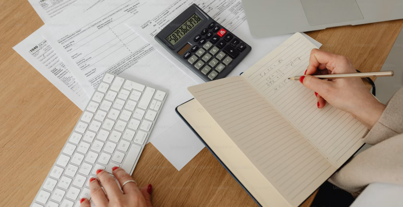 bureau où est posé un cachier, une calculatrice et des documents