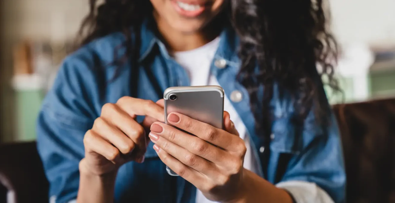 Une jeune femme consulte son application bancaire mobile sur son smartphone dans un café